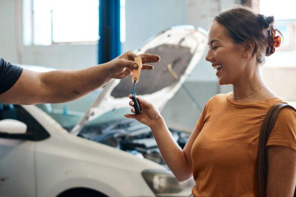 Happy customer receives car keys from service advisor after complete auto repair in San Antonio TX