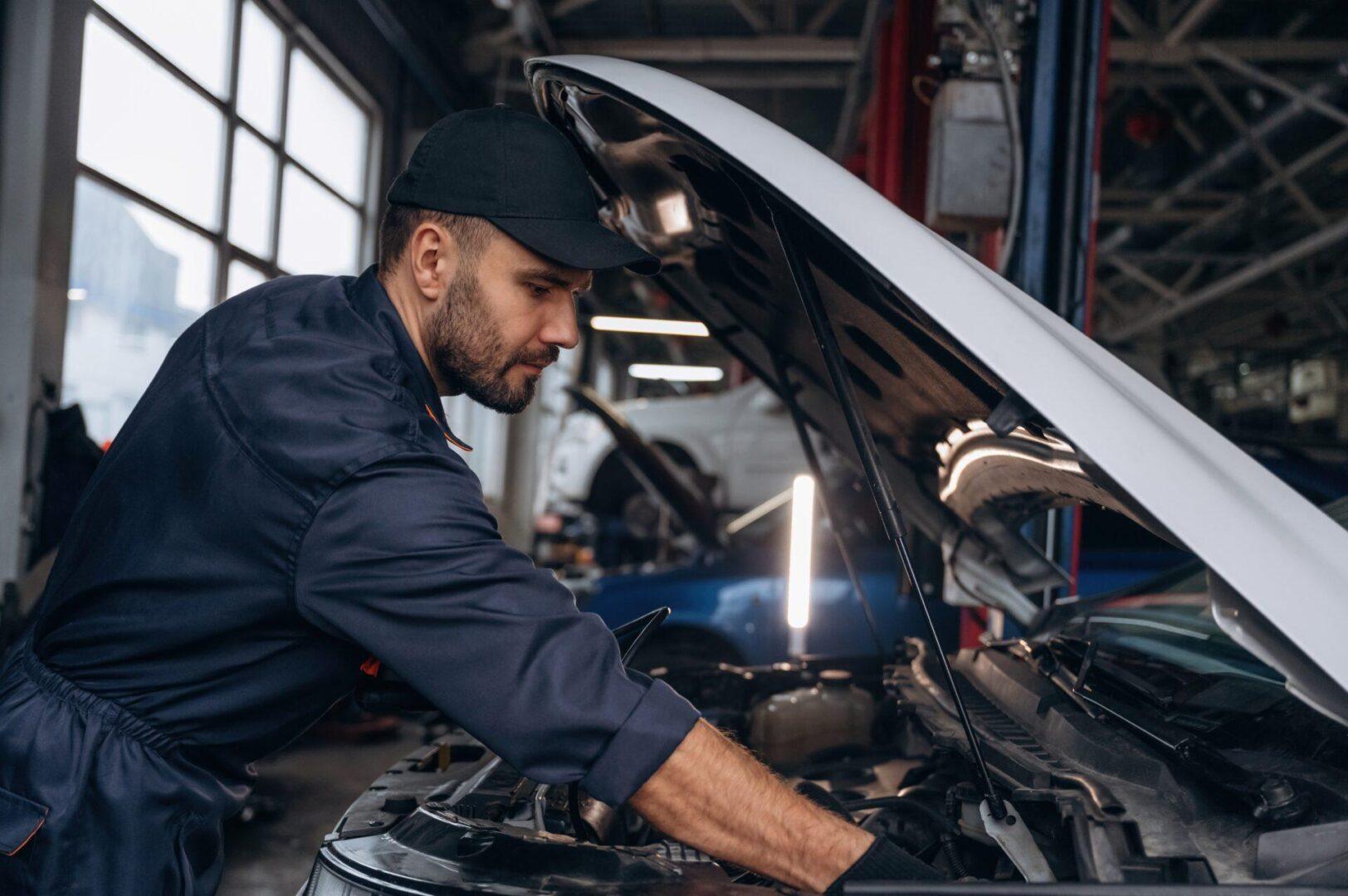 Certified mechanic performing engine repair under car hood in San Antonio TX
