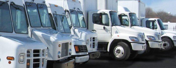 Line of fleet trucks and commercial vehicles parked for maintenance and repair in San Antonio TX