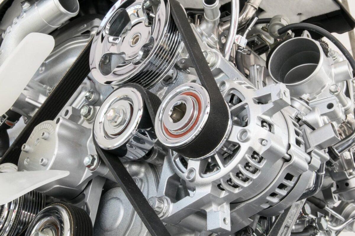 Alternator and serpentine belt visible on the front of a running engine during a vehicle inspection in San Antonio.