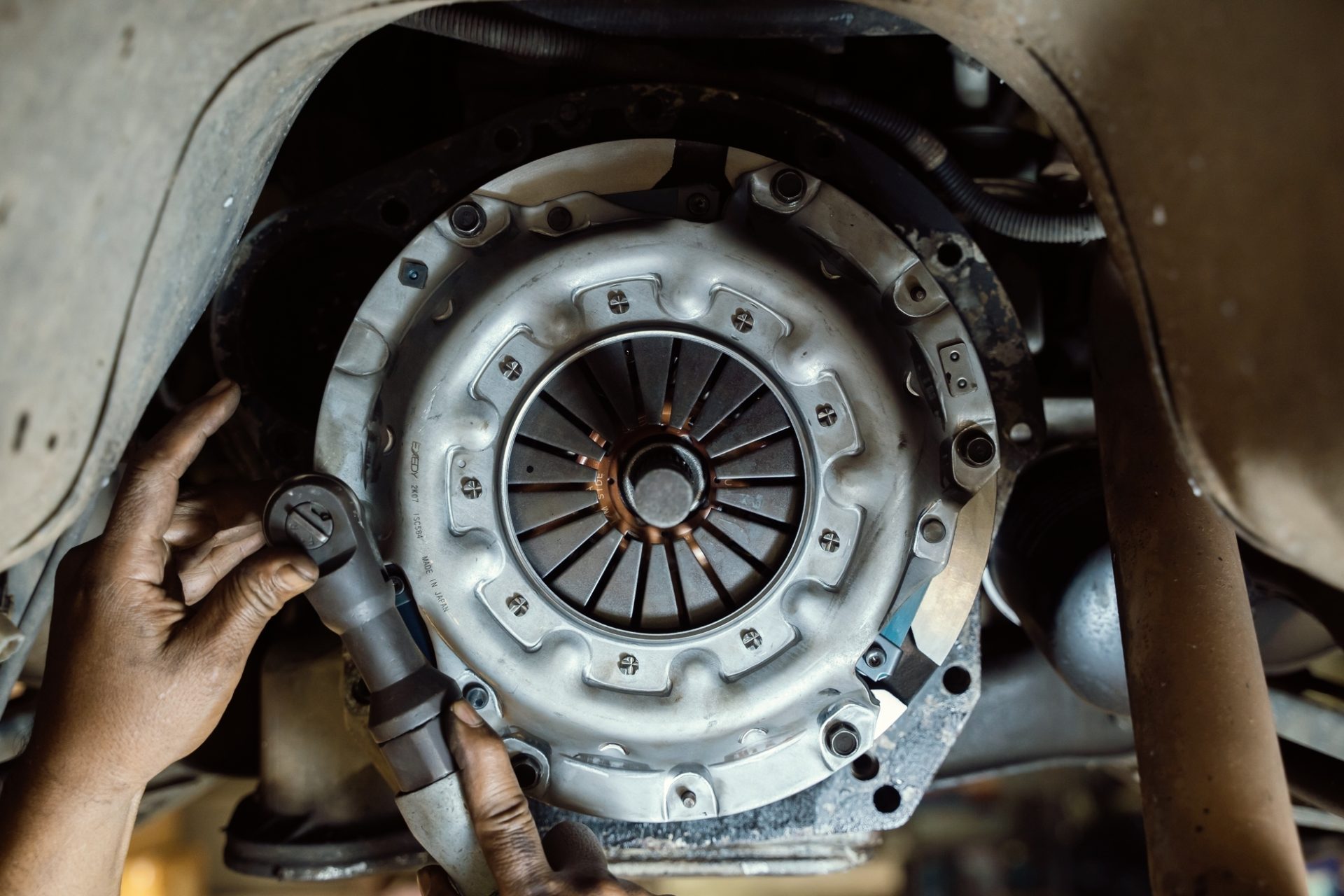 Close-up of mechanic installing a heavy-duty commercial truck clutch and flywheel.